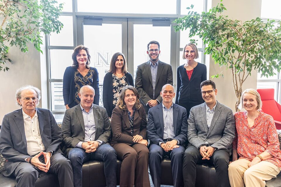 Speakers and organizers for Nebraska Symposium on Motivation sitting and standing behind couch