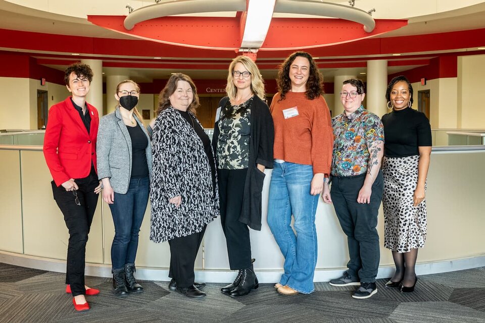 Speakers and organizers of 70th Nebraska Symposium on Motivation standing in front of half-wall